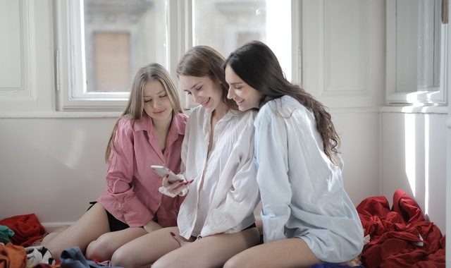 group-of-young-women-browsing-smartphone-together-in-messy-3794163